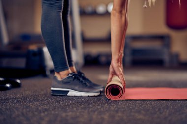 Mat gevşemek ve egzersizler için hazırlanıyor kafkas kadın kapatın. Spor salonu iç. sağlıklı yaşam konsepti.