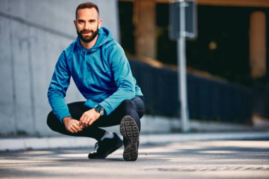 Maraton çalıştırmadan önce germe sakallı adam. Sağlıklı yaşam konsepti.