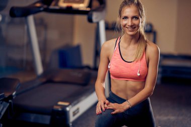 Şekilli kadın bacaklar için egzersiz yapıyor ve aşağı bakıyor. Spor salonu iç, sağlıklı yaşam konsepti.