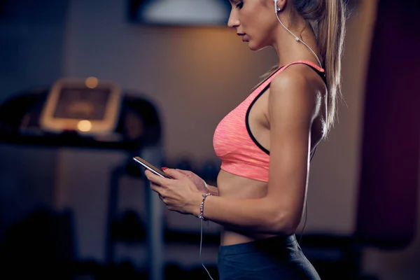 Mujer Usando Teléfono Inteligente Mientras Está Pie Gimnasio Cinta Correr — Foto de Stock