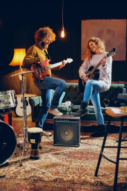 Akustik gitar bas çalmaya adam beyaz kadın. Ev stüdyosu iç.