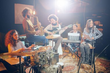 Grup çalışması ev Studio. Kadının aletleri oynamak grubun geri kalanı şarkı.