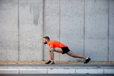 Sportif adam çalıştırmadan önce bacaklarını germe. Sağlıklı yaşam konsepti.