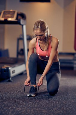 Bağcık bağlama ve kneelin spor giyim uygun sportif sarışın kadın