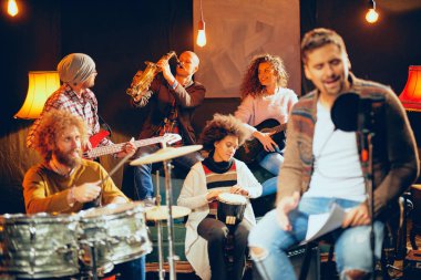 Çok kültürlü bir grup konser için pratik. Ev stüdyosu iç.