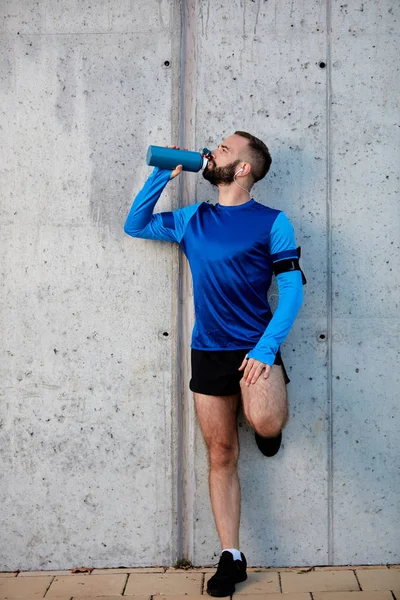 Muž Odpočinuli Běh Pití Vody Přitom Stát Proti Zdi Koncept — Stock fotografie