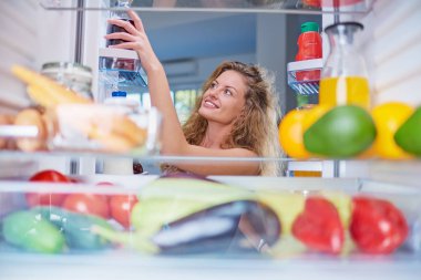 Dolap dolusu yiyecek yiyecek çekici bir kadın. Resim f