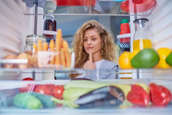 Vrouw staande voor koelkast vol boodschappen en het nemen van j — Stockfoto