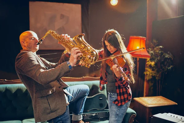 Two talented musicians playing violin and saxophone. Home studio — Stock Photo, Image