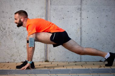Sportif adam çalıştırmadan önce bacaklarını germe. Sağlıklı yaşam konsepti.