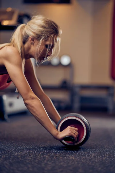 Close-up van de mooie vrouw doen oefeningen voor abs. gezonde levensstijl concept. Sportschool interieur. — Stockfoto