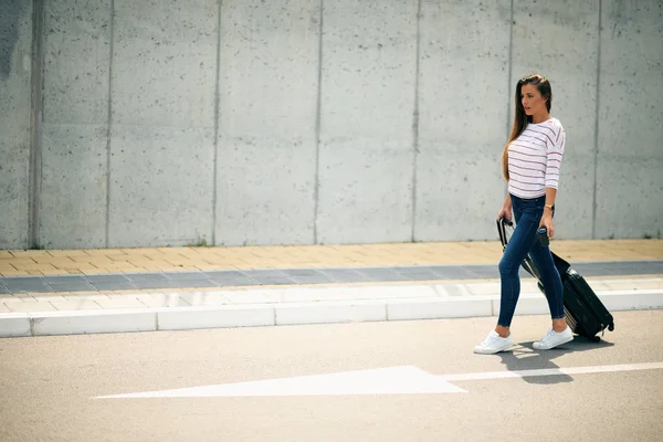 Mujer sosteniendo café y equipaje mientras camina por la calle . —  Fotos de Stock