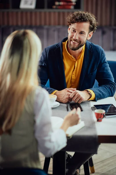 Zwei junge attraktive Kollegen sitzen in der Cafetaria und sprechen über das Projekt. — Stockfoto