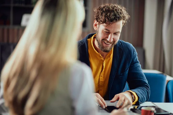 Two young attractive colleagues sitting in cafetaria and talking about project. — Stock Photo, Image