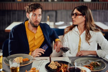 Çok ırklı arkadaşlar restoranda oturan, alkol içme, sohbet ve akşam yemeği için hamburger yeme. 