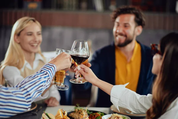 Quatro freinds muliétnicos felizes vestiram torcida casual inteligente com álcool enquanto sentado no restaurante . — Fotografia de Stock