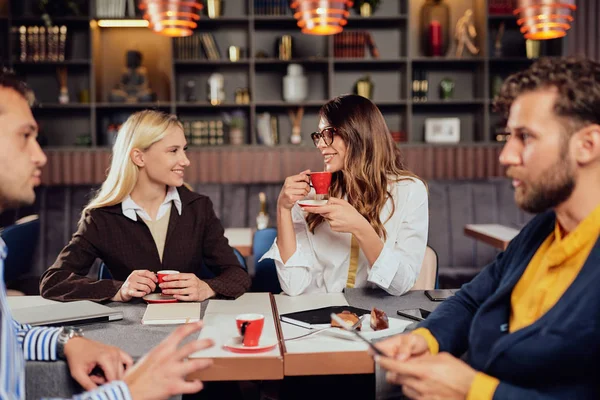 Group of multiethnic colleagues sitting at restaurant and talkin — Stock Photo, Image