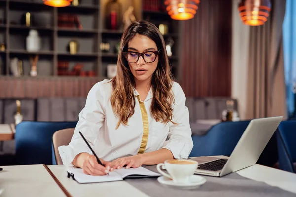 Kafeteryada oturan güzel, ciddi bir beyaz esmer.