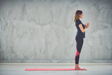 Sun Salution yoga p mat indors üzerinde duran Kafkas esmer