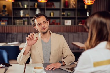 İki çok kültürlü ciddi meslektaşları restoranda oturan akıllı rahat giyinmiş ve proje hakkında tartışıyor.