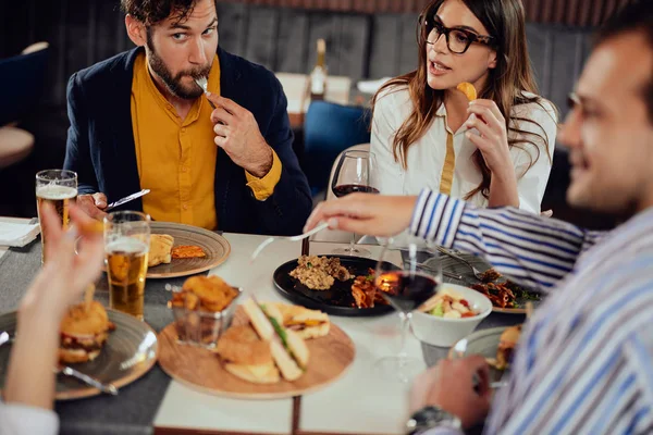 Többnemzetiségű barátok ül étterem, alkoholfogyasztás, csevegés és miután hamburgerek vacsorára. — Stock Fotó