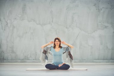 Nilüfer duruşu içinde paspas Üzerinde oturan beutiful kadın.