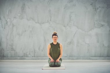 Thunderbolt yoga poz oturan sprtswear güzel Kafkas esmer Ön görünümü.