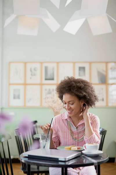 Charmante positieve gemengde race vrouw zittend in café en limonade drinken. — Stockfoto