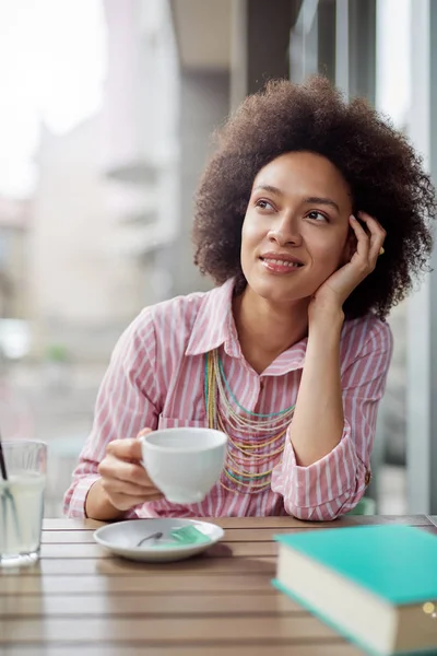 Aantrekkelijke mixed race vrouw zittend in Cafe en genieten van haar koffie. — Stockfoto