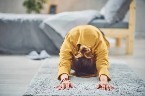 Брюнетка делает расширенную позу йоги для детей на ковре в спальне . — стоковое фото