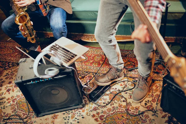 Musicisti che fanno le prove in studio. Sul pavimento amplificatori, laptop e cuffie . — Foto Stock