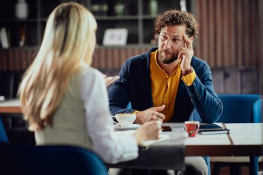 İki genç çekici meslektaşları kafeteryası oturan ve proje hakkında konuşmak.