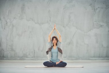 Nilüfer duruşu içinde paspas Üzerinde oturan beutiful kadın.