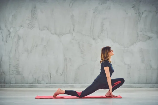 Junge schlanke Frau beim Ausfallschritt auf der Knie-Yoga-Haltung. — Stockfoto