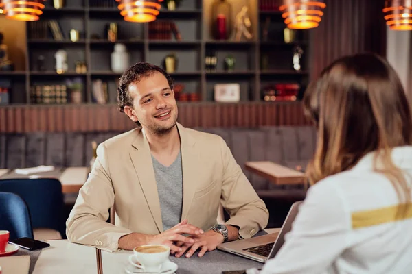 Двоє мультикультурних усміхнених колег одягнені розумні випадкові сидять в ресторані і обговорюють проект . — стокове фото