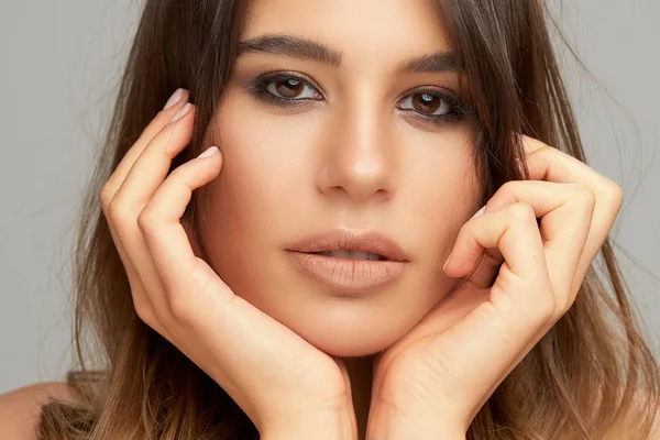 Cabeza de hermosa morena caucásica posando frente a fondo gris. Belleza fotografía . — Foto de Stock