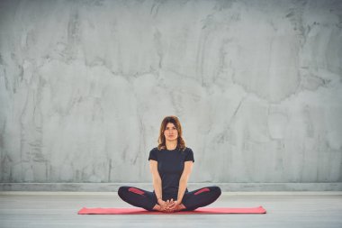 Sukhasana'da mat yalınayak oturan çekici Kafkas esmer.