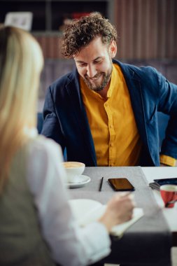 İki genç çekici meslektaşları kafeteryası oturan ve proje hakkında konuşmak.
