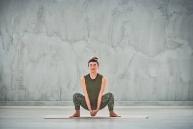 Yeşil spor giyim Büyüleyici Kafkas esmer Tanrıça yoga poz yapıyor.