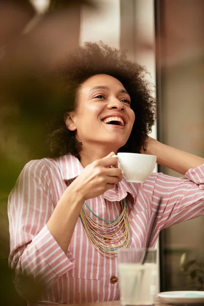 Aantrekkelijke mixed race vrouw zittend in Cafe en genieten van haar koffie. — Stockfoto