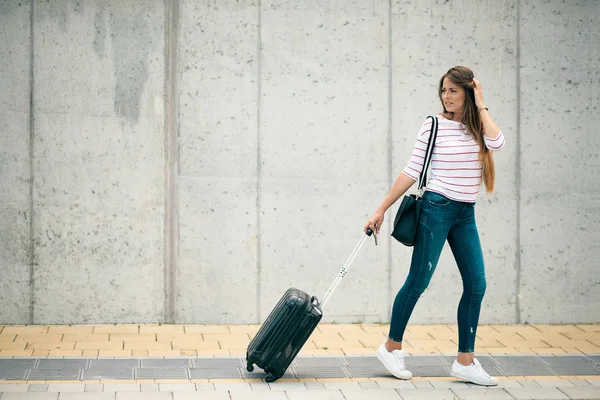 Kvinna som håller bagage när du går på gatan. — Stockfoto