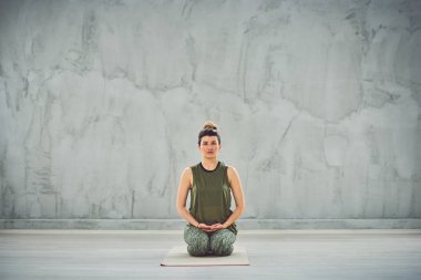 Thunderbolt yoga poz oturan sprtswear güzel Kafkas esmer Ön görünümü.