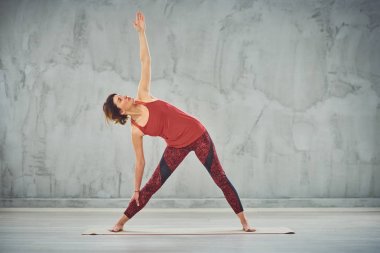 Üçgen yoga duruş yapıyor kırmızı spor yalınayak Çekici esmer.