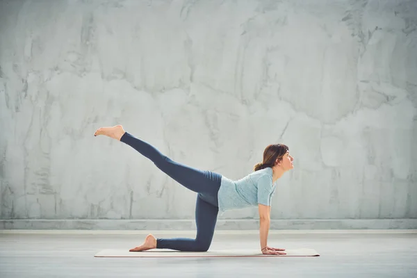 Güzel ince Caucasain esmer mat yalınayak diz çökmüş ve bir Bacaklı Masa yoga poz yapıyor. — Stok fotoğraf