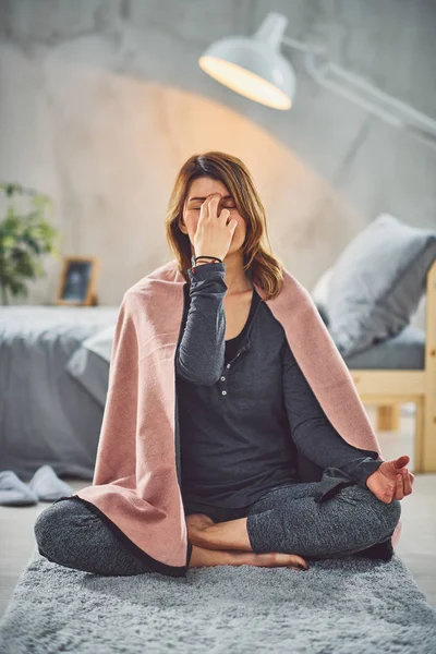 Hermosa morena caucásica sentada en pose de loto yoga y practicando la respiración. Dormitorio interior, rutina de la mañana . — Foto de Stock