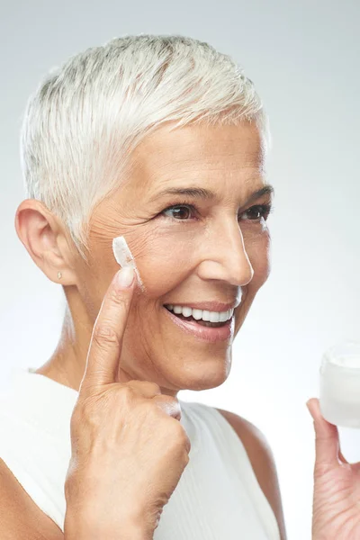 Linda mulher sênior branca sorridente experimentando nova anti idade — Fotografia de Stock