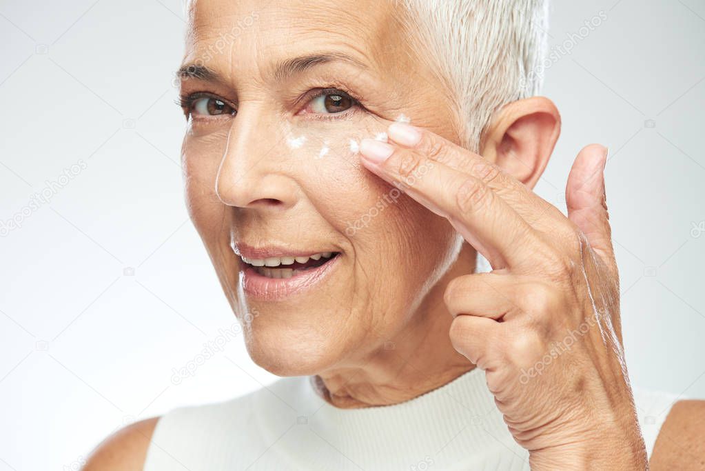 Gorgeous smiling Caucasian senior woman trying out new anti age 
