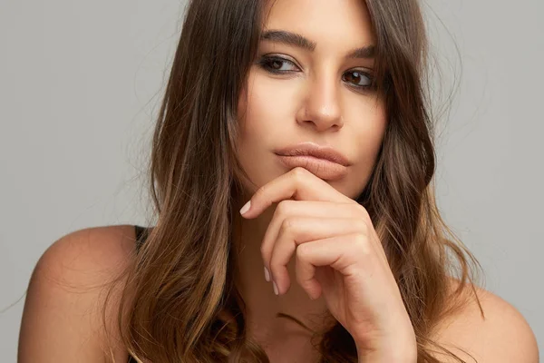 Headshot of beautiful Caucasian brunette posing in front of grey background. Beauty photography. — Stock Photo, Image