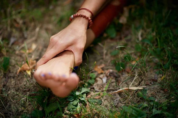 Gros plan de la femme tenant la jambe. Pratique du yoga dans la nature concept — Photo