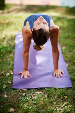 Fit Kafkas esmer sabah doğada mat ters tahta yapıyor. Yoga pratik kavramı.